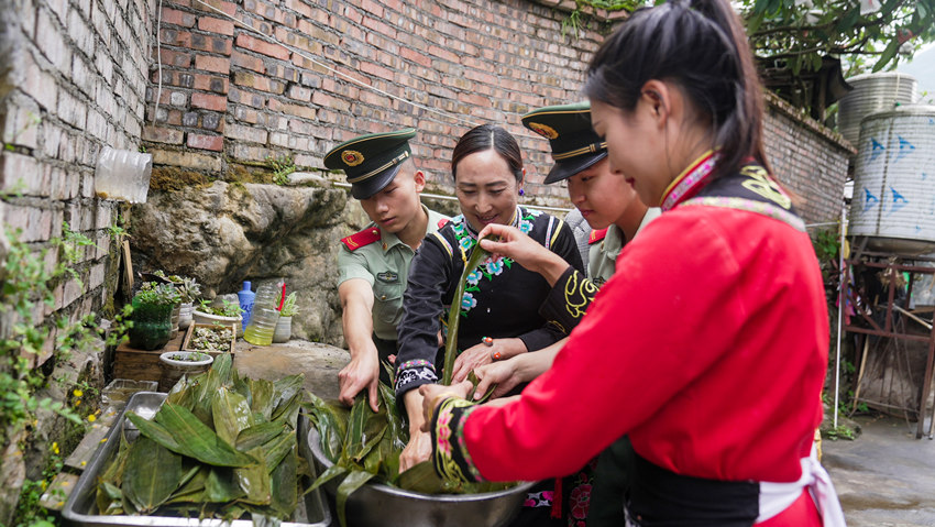 官兵和羌族群眾一起洗粽葉。武警綿陽支隊供圖