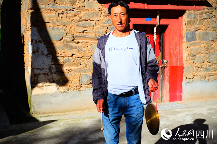 王爾單拿著當晚提醒村民的鑼。陳瀟洋攝