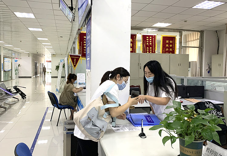 政務大廳內，工作人員幫助群眾辦理業務。綿竹市融媒體中心供圖