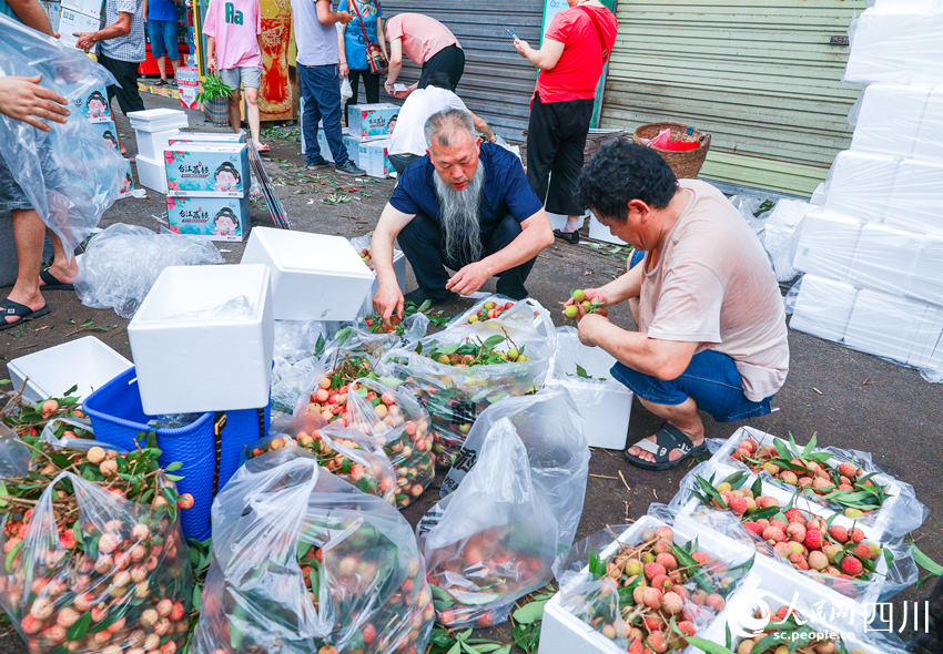 市民將選購好的荔枝直接交給物流企業打包快遞給遠方的親朋。李貴平攝