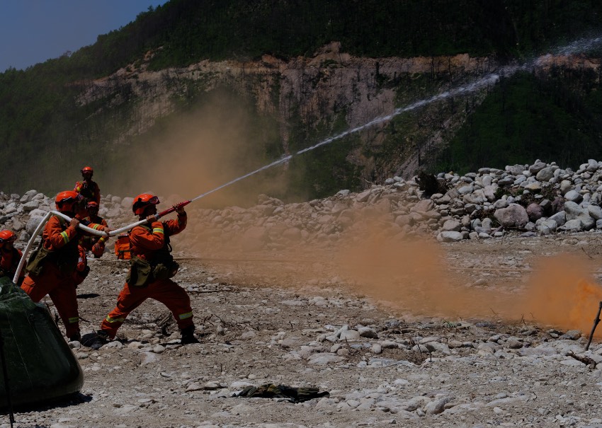 消防救援人員以水滅火撲打模擬火線。四川省森林消防總隊供圖