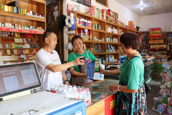 張在寬與妻子為顧客提供掃碼支付服務。何丹攝