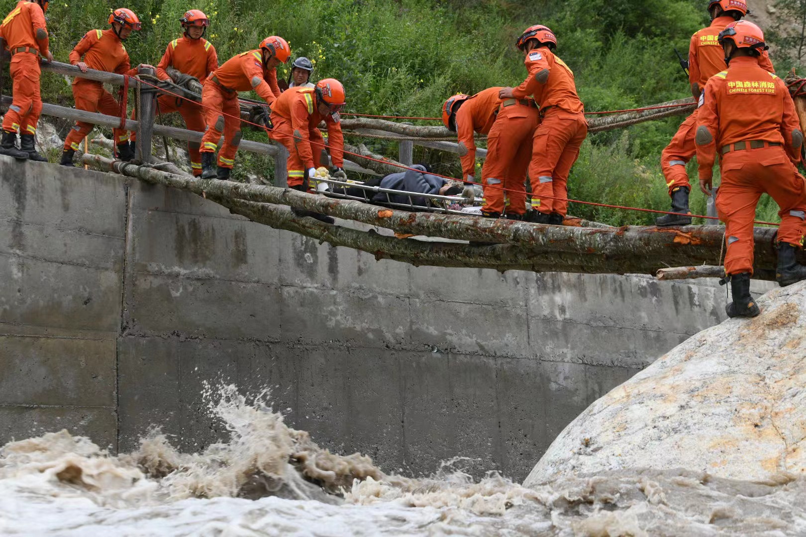 加固簡易橋梁，森林消防員護送傷員就醫。四川省森林消防總隊供圖