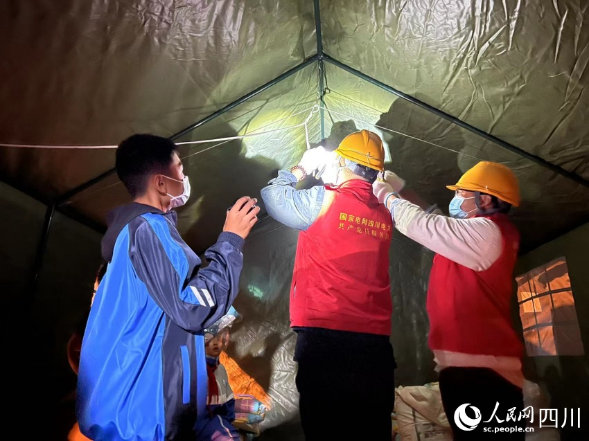 小朋友幫助電力工人照明。湯衛攝