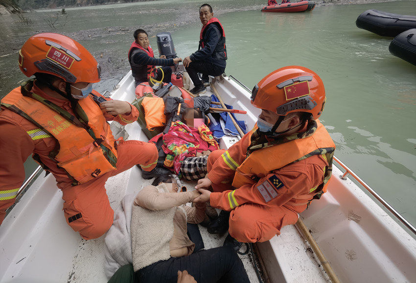 森林消防員利用橡皮艇在堰塞湖救助被困者。四川省森林消防總隊供圖