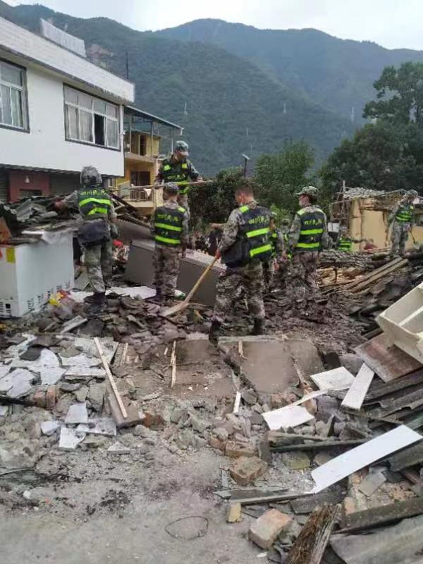 民兵在廢墟中開展搜救。四川省軍區供圖