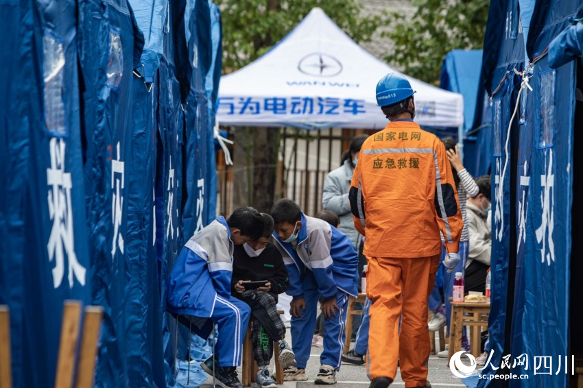 9月6日上午，國網眉山供電公司搶險突擊隊在墨西鎮貢嘎懸崖溫泉酒店救災安置點，抓緊時間率先對24頂住有小朋友的帳篷接通臨時電源。王鴻飛攝