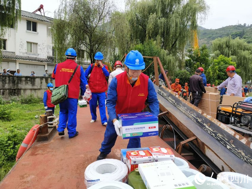 圖為曹浩和隊員們正將應急物資搬運上沖鋒舟。廖亮攝