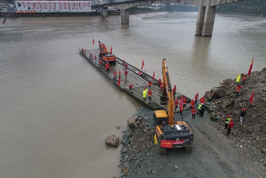 首輛重型裝載機被推上動力船。蜀道集團供圖