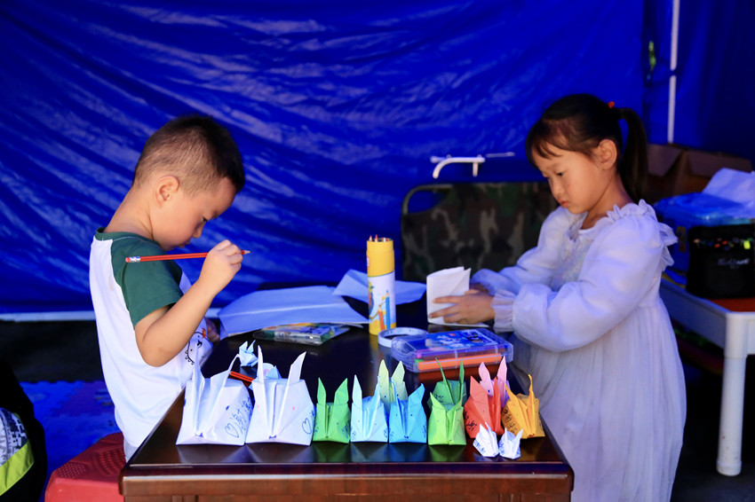 安置點的小朋友正在準備禮物。人民網 朱虹攝