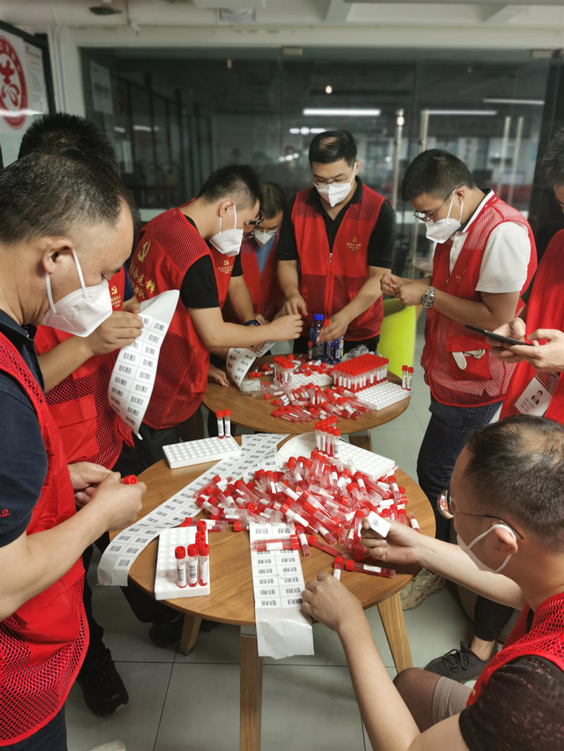 成都銀行高新支行志愿服務隊在錦江區成龍街道卓錦城社區協助開展核酸采樣試管條形碼粘貼工作。成都市國資委供圖