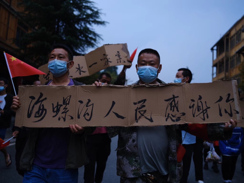 當地群眾手寫感謝牌，歡送救援隊伍。程雪力攝