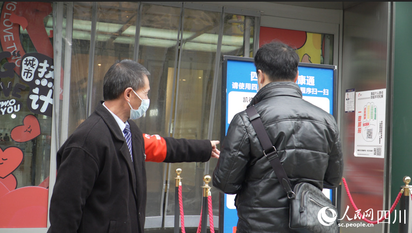 商場工作人員正在提醒市民掃場所碼。侯杰攝