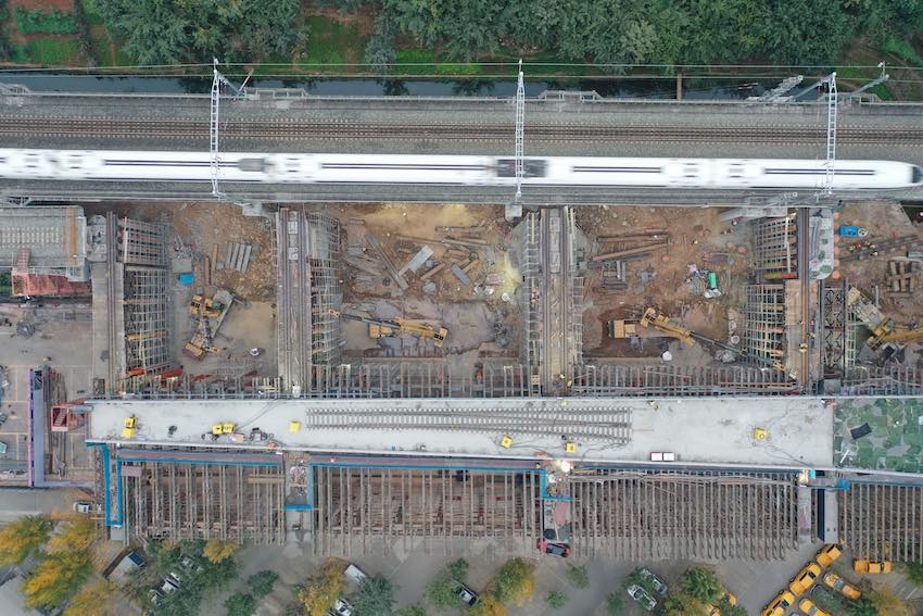施工現場，一列列車飛速從施工點位旁駛過。成蘭公司供圖
