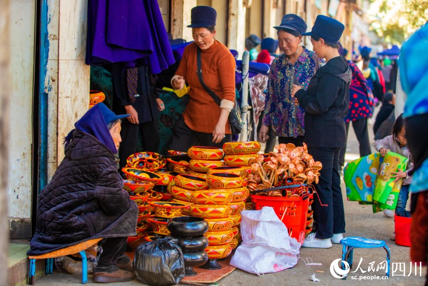 布拖縣城一處市場內,市民購買彝族年要用的新碗和勺子。歐其你拉攝