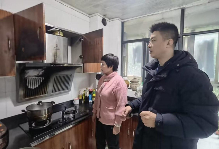 黃勇向吳阿姨講解安全用火用電常識。四川煙草供圖