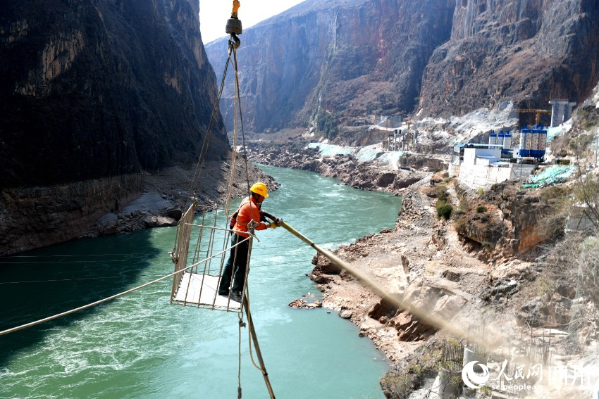 工人在空中對懸崖峭壁上的松散邊坡進行噴射混凝土加固。賈巴爾且攝