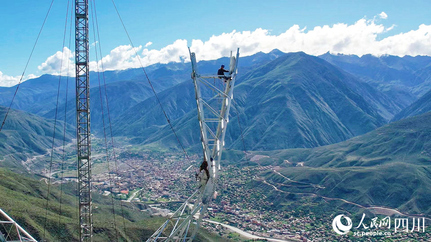 在四川省甘孜州巴塘縣至瀾滄江500千伏線路施工現場，電力工人正在高空進行鐵塔組立作業。劉洋攝