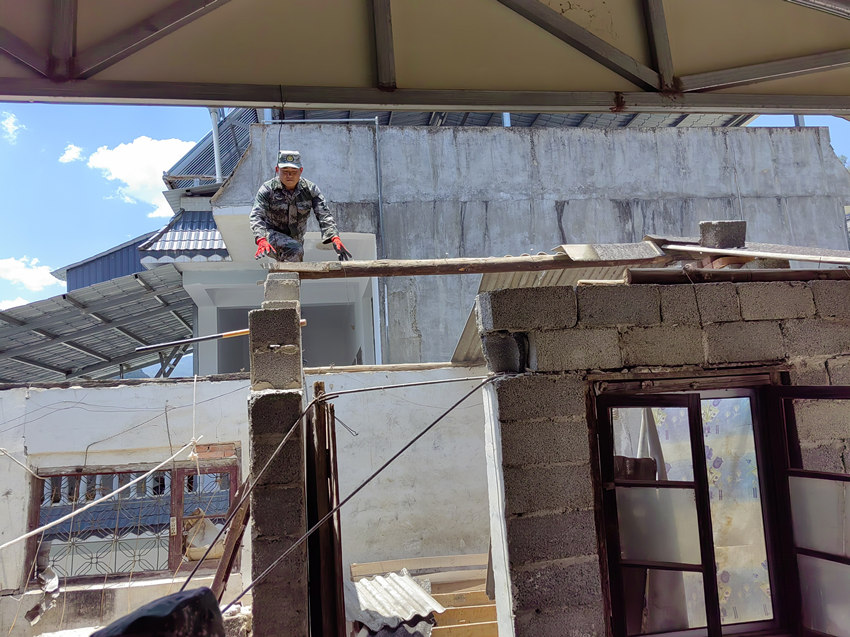 楊愛理在房頂排除隱患。陸軍第77集團軍某旅供圖