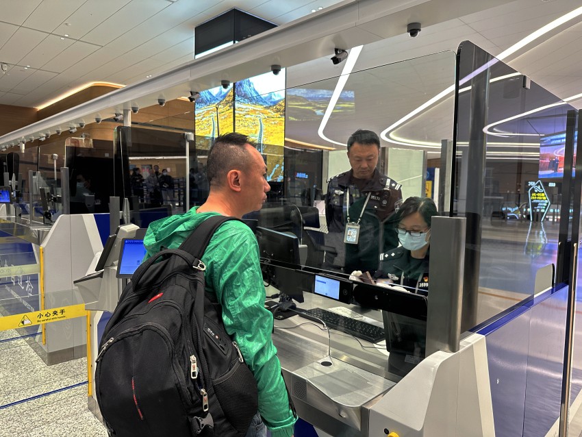 成都邊檢站移民管理警察為首航旅客辦理出境手續。成都邊檢供圖