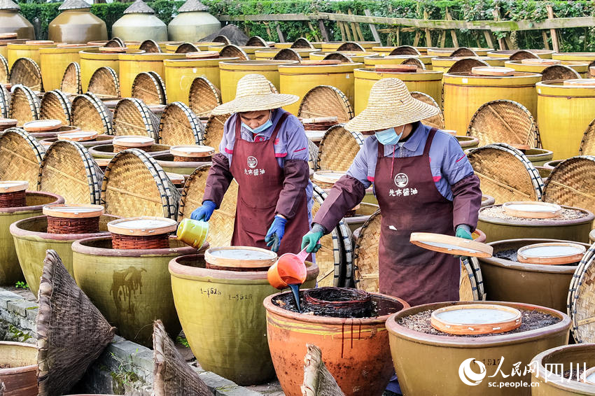 工人在露天曬場里忙碌生產。李貴平攝