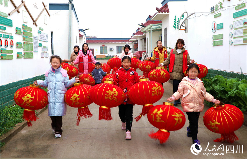 黨員志愿者和小朋友為群眾集中送燈籠。潘建勇攝