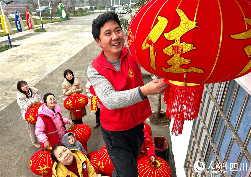 黨員志愿者為群眾掛燈籠。潘建勇攝