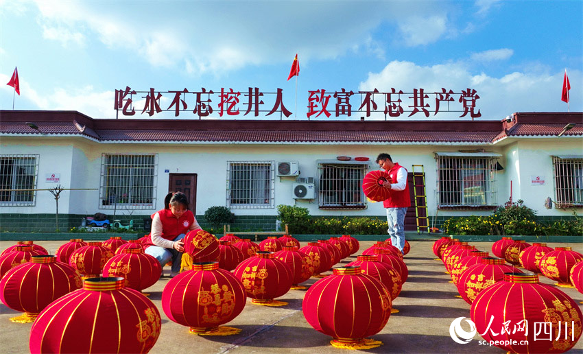 黨員志愿者正在整理送給群眾的燈籠。潘建勇攝