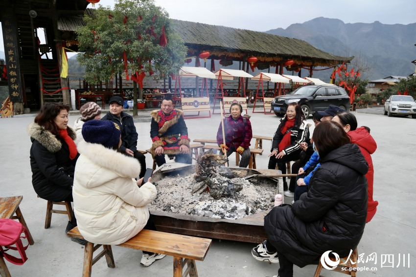 與村民和游客正在聊天的陳愛軍。人民網記者 朱虹攝