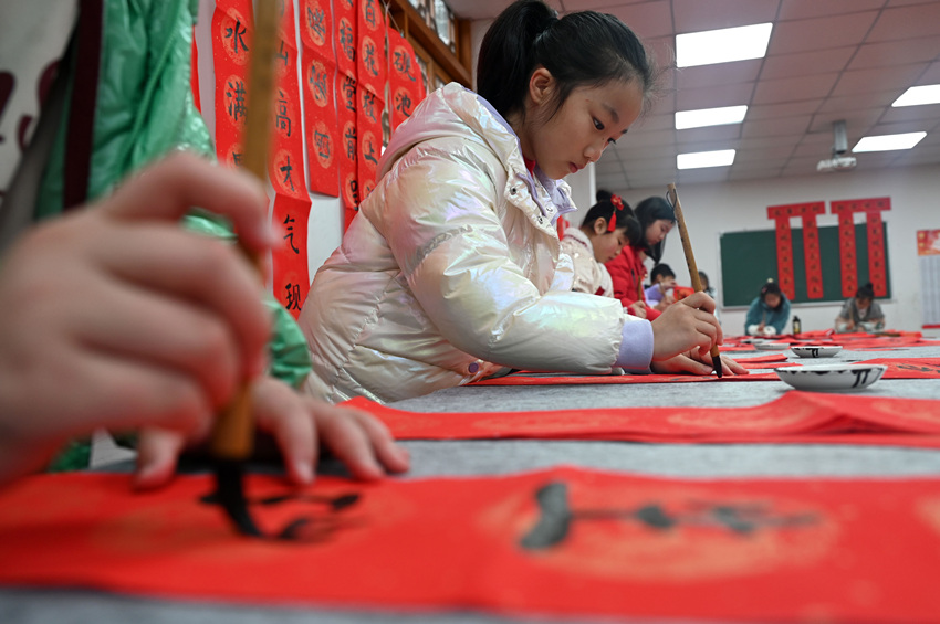 為社區居民書寫春聯和“?！弊?。蘭自濤攝