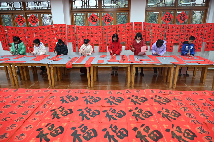 為社區居民書寫春聯和“?！弊?。蘭自濤攝