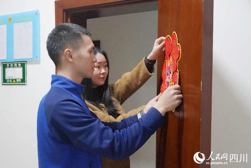 李明挺與熊一檔一起布置房間節日氛圍。曾平攝