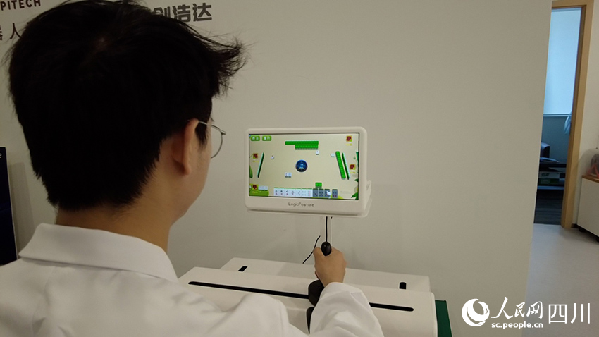 工作人員正在演示上肢康復機器人。人民網記者 郝帥攝