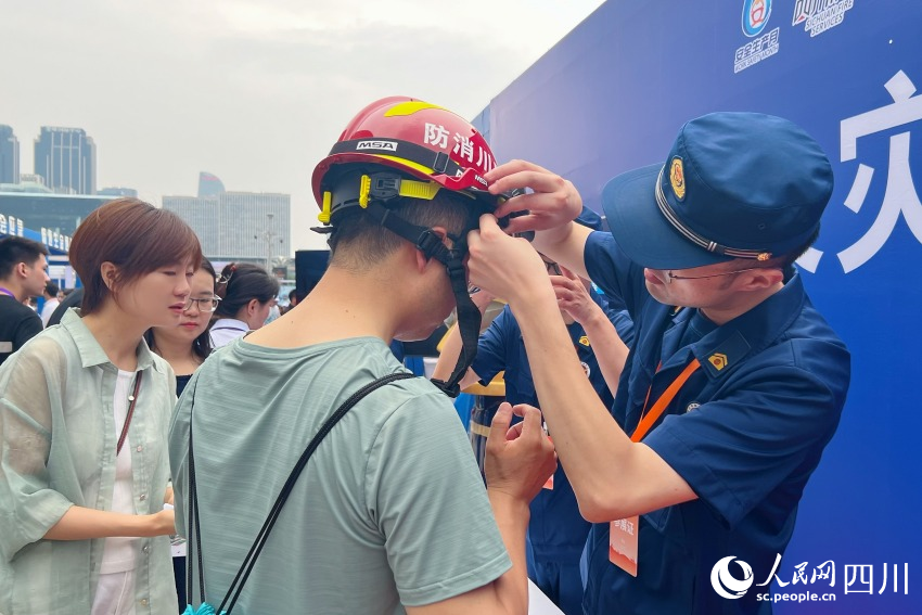 工作人員幫參與互動體驗的市民佩戴安全裝備。人民網 趙祖樂攝
