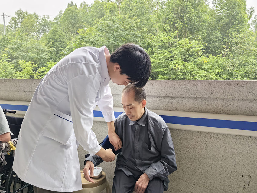 護士姚炎鋒在給老人測量血壓。姜曉鳳攝