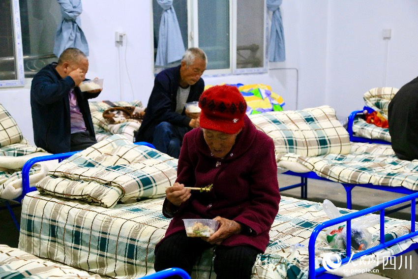 7月21日晚7點，漢源縣馬烈鄉新華小學安置點的村民正在吃晚餐。人民網記者 朱虹攝