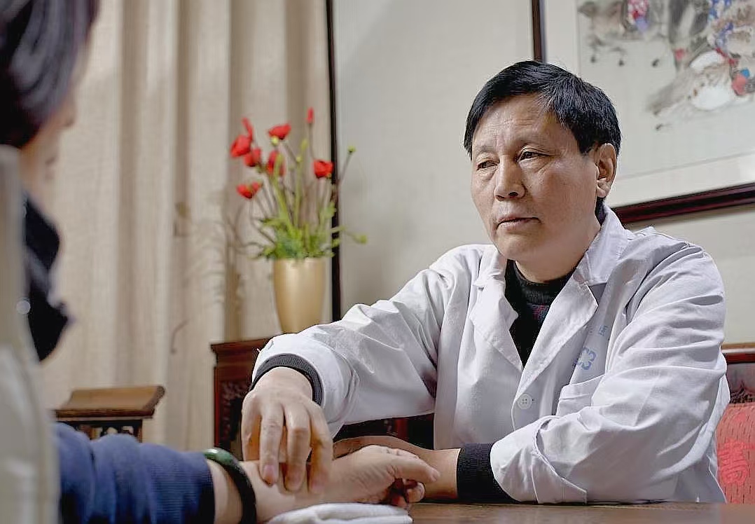 四川省名中醫唐德厚正在為患者切脈問診。受訪者供圖