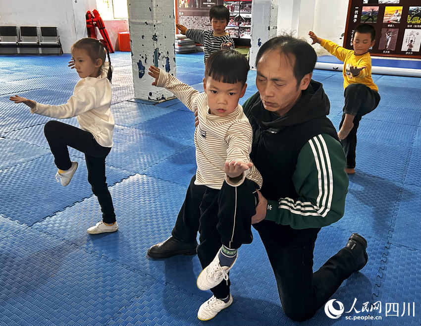 張鴻桀在給弟子指導表演動作。人民網 彭茜攝