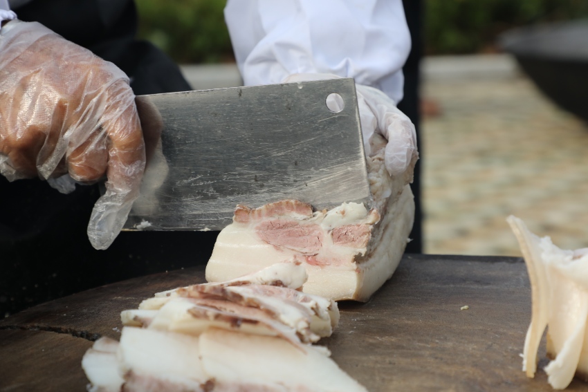 正在切煮好的豬肉。德昌縣委宣傳部供圖