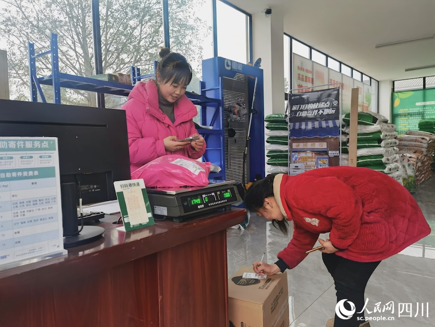 騎龍村金通快遞驛站，農戶正在簽收網購的物品，農村路的通暢也助力了工業品的下行。人民網記者 郭瑩攝