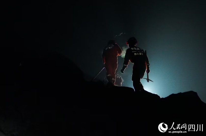 消防救援人員利用搜救犬、生命探測儀從下至上對垮塌廢墟進行搜索。宋豪新、黃超攝