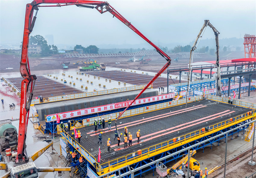 施工人員在西渝高鐵四川省廣安華鎣市境內的廣安東站，冒著陰雨天氣制梁場澆筑箱梁。邱海鷹攝