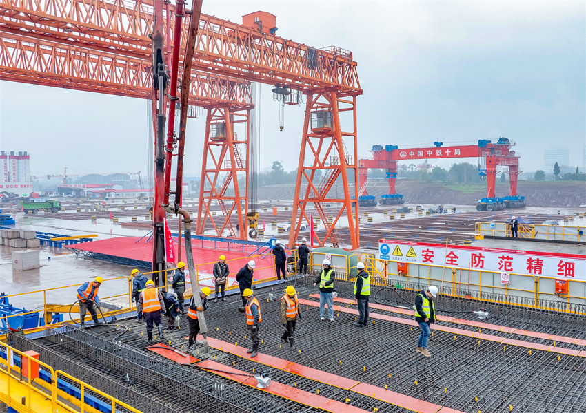 施工人員在西渝高鐵四川省廣安華鎣市境內的廣安東站，冒著陰雨天氣制梁場澆筑箱梁。邱海鷹攝