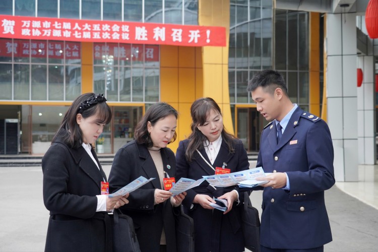 稅務干部向萬源“兩會”代表宣傳稅費政策。萬源市稅務局供圖