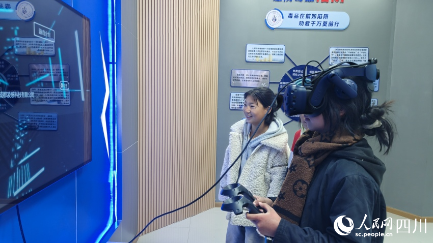 布拖中學禁毒防艾教育基地中，2名學生在體驗VR游戲。陳萱攝