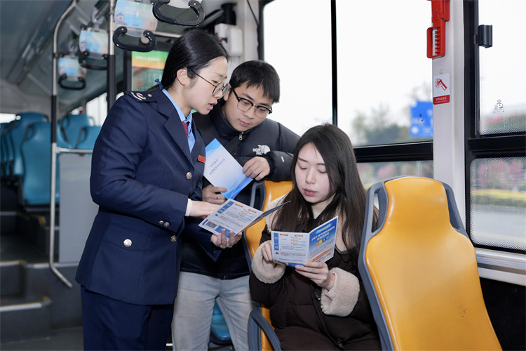 稅務干部在公交車上為納稅人繳費人講解稅收政策。成都市稅務局供圖