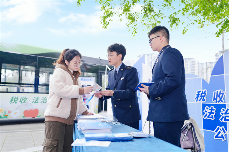 稅務干部在公交車站為納稅人講解稅收政策。成都市稅務局供圖