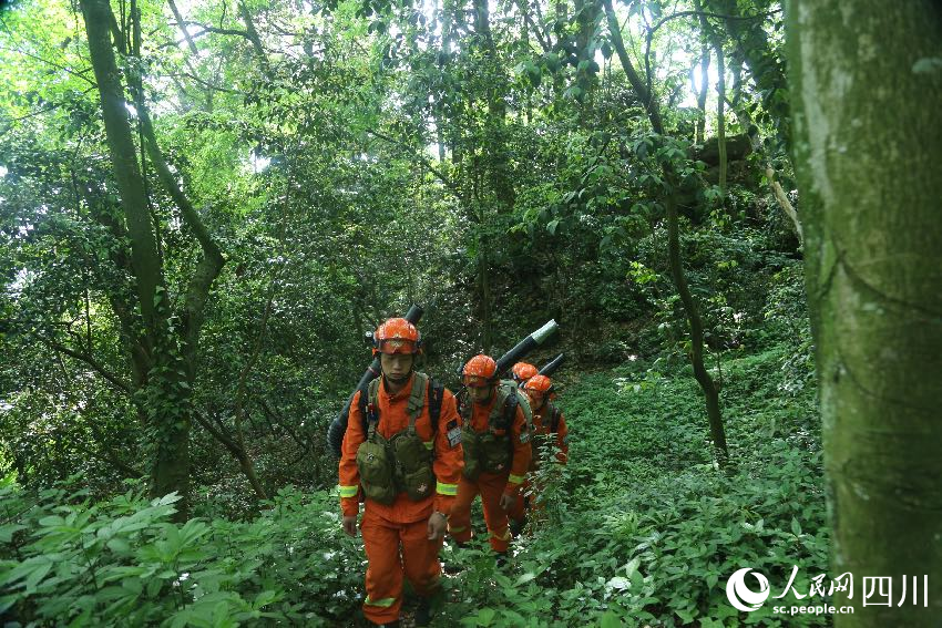 5月1日，林區深處，消防員們正在巡護火情火點。程雪力攝