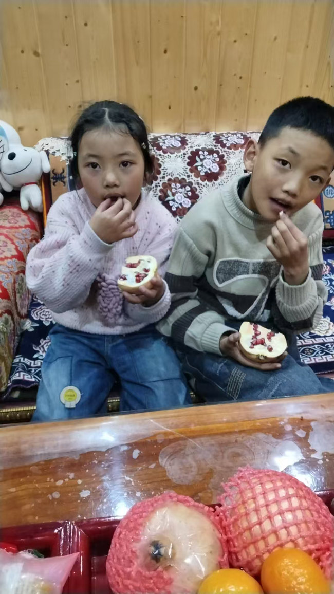 高原上的小朋友吃到了石榴。受訪者供圖