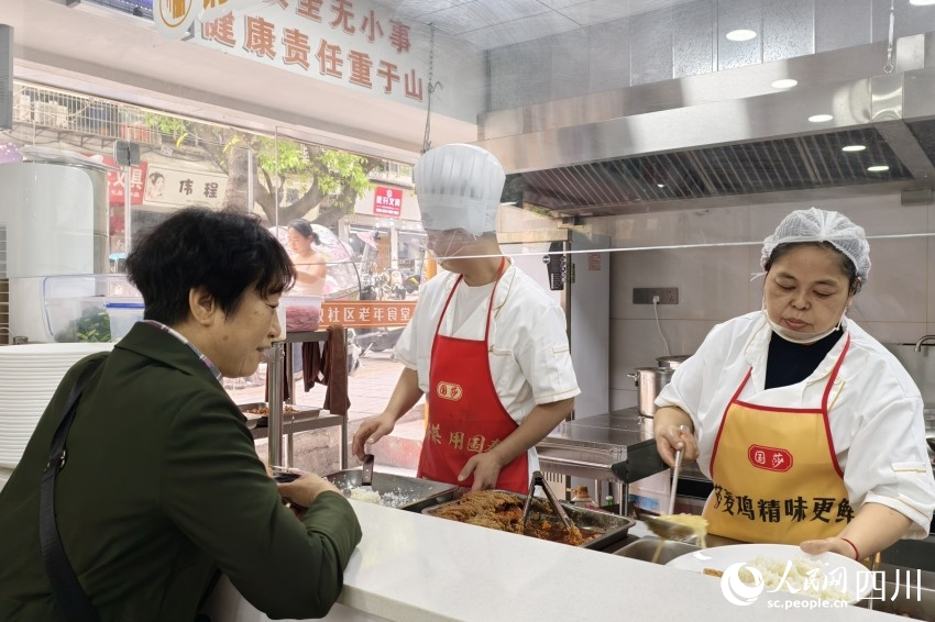 老年食堂取餐口前，廚師正在按需為老人打飯。人民網 趙祖樂攝